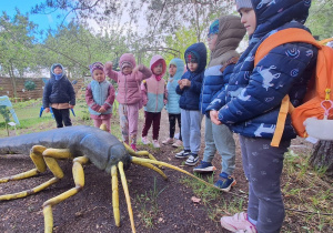 Dzieci z przewodnikiem zwiedzają wystawę rzeźb owadów, mikroorganizmów i grzybów