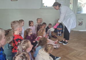 Prowadząca wykonuje eksperymenty z suchym lodem, powiada o nich dzieciom i angażuje dzieci do części zabaw z suchym lodem