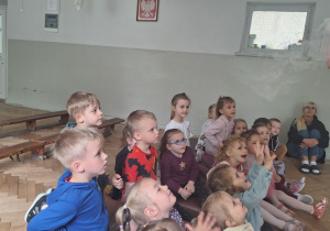 Prowadząca wykonuje eksperymenty z suchym lodem, powiada o nich dzieciom i angażuje dzieci do części zabaw z suchym lodem