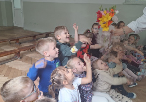 Prowadząca wykonuje eksperymenty z suchym lodem, powiada o nich dzieciom i angażuje dzieci do części zabaw z suchym lodem
