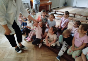 Prowadząca wykonuje eksperymenty z suchym lodem, powiada o nich dzieciom i angażuje dzieci do części zabaw z suchym lodem