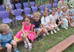 Grupa Biedronek siedzi na ławeczce i czeka na rozpoczęcie uroczystości