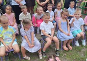 Grupa Zajączków siedzi na ławeczce i czeka na rozpoczęcie uroczystości
