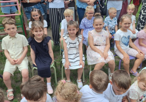 Grupa Zajączków siedzi na ławeczce i czeka na rozpoczęcie uroczystości