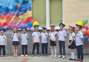 Dzieci stoją na scenie i mówią wiersze