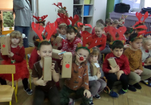 Dzieci z grupy III siedzą ze swoimi prezentami od Mikołaja