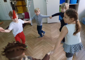 Dzieci tańczą w dużym kole.